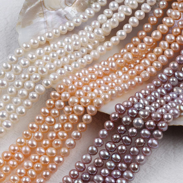 Multi-color freshwater pearls strands displayed on a shell, natural pearl beads. Main image